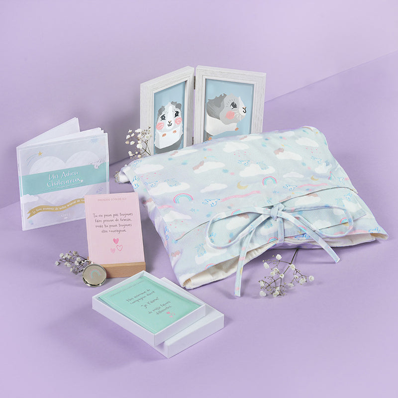 Contenu du Coffret Funéraire pour petits animaux de la marque Kavee sur fond lila, incluant un linceul, un cadre photo, des cartes et un livre