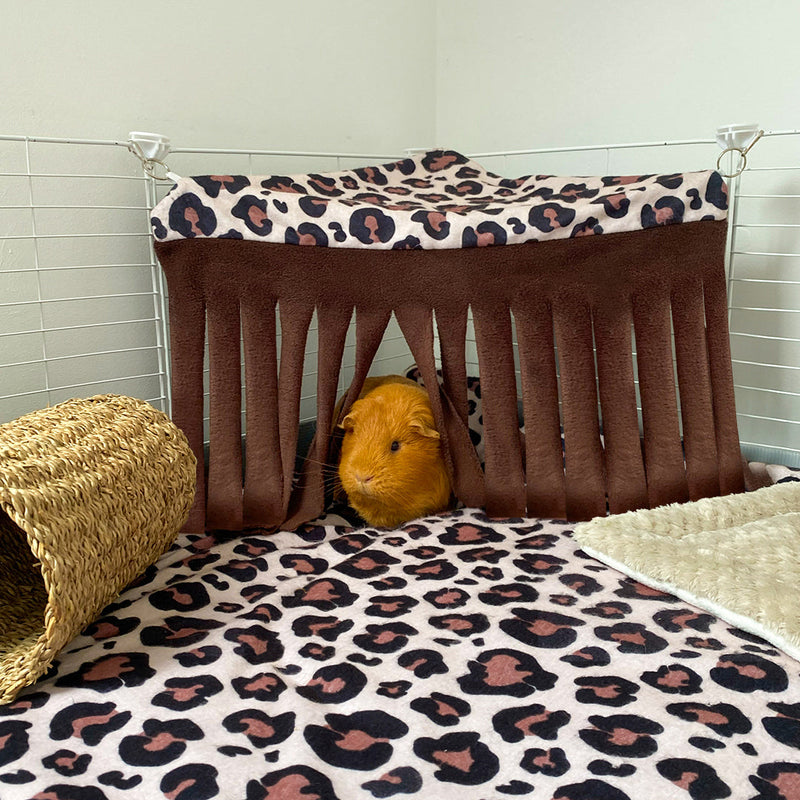 cochon d'Inde roux utilisant un rideau de coin en polaire coloris marron léopard pour cavy cage de la marque Kavee